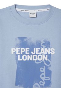 Lichtblauwe katoenen t-shirt met ronde hals, voorzien van een witte bedrukte graphic met de tekst "PEPE JEANS LONDON" en golvende accenten.