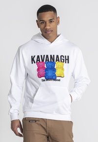 Sudadera blanca con un gráfico frontal que presenta tres osos de peluche coloridos (rosa, azul, amarillo) y el texto "KAVANAGH El Escuadrón del Oso."