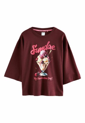 Burgundin lyhythihainen t-paita, jossa on jäätelösundae-kuvio kirsikoilla ja teksti "Sundae lempipäiväni!" vaaleanpunaisella.