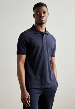 Navy polo shirt made of cotton with a collar, short sleeves, and a subtle logo on the chest. Features a classic fit and soft texture.