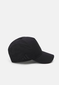 Črna kapa s ukrivljenim vizirjem, izdelana iz lahkega blaga. Ima teksturiran panel in temno akcentirano Adidasovo trojno črto.