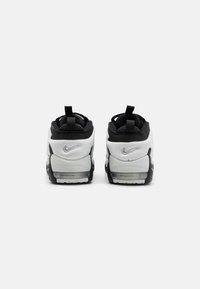 Nike Air Max tossud valgete ja mustade värvidega, millel on tekstuuriga võrkmaterjalist ülemine osa, pehmendusega tald ja läbipaistev õhuüksus kannal.