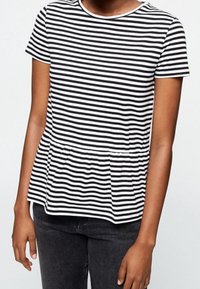 Svart och vit randig kortärmad topp med rund hals och rynkad peplum vid midjan. Mjuk, lättviktig tyg.