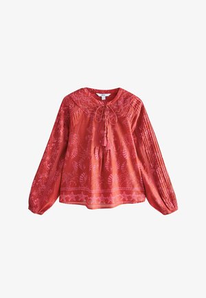Červená blůza s dlouhým rukávem a kulatým výstřihem, s detailem kravaty a výšivkami vzorů listů a hvězd, s nabíranými texturovanými rukávy.