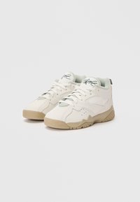 Białe sneakersy z gładką skórzaną cholewką, siateczkowymi akcentami, zielonymi detalami i beżową teksturowaną gumową podeszwą. Posiadają okrągłe sznurowadła i wyściółkę przy kołnierzu.
