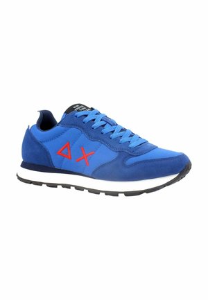 Scarpe da ginnastica blu con una combinazione di materiali in suede e tessuto, con accenti rossi a contrasto, punta tonda e suola bianca.
