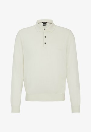 Langermet kremfarget pikésveter laget av mykt stoff, med en placket med tre knapper, ribbestrikkede mansjetter og en lydløs logo på brystet.
