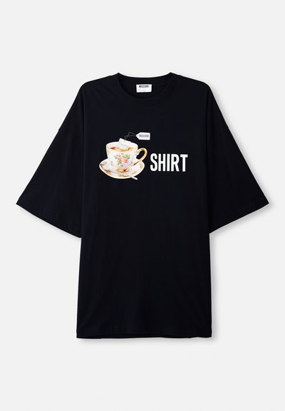 T-shirt noir oversized avec un graphisme d'une tasse de thé fleurie avec un sachet de thé, texte "MOSCHINO" et "SHIRT" en lettres blanches épaisses.