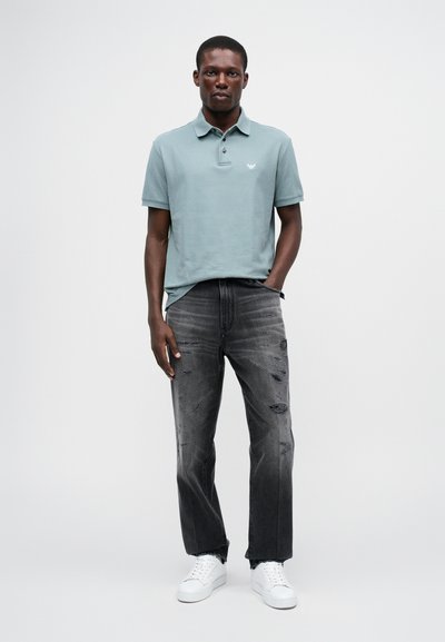Polo tri�čko vo svetlozelenej bavlnenej zmesi, s golierom a krátkymi rukávmi. Nosené s čiernymi roztrhnutými džínami a bielymi teniskami.