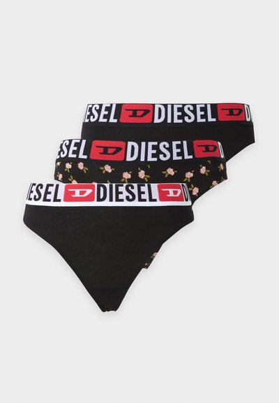 Trois strings noirs de la marque Diesel avec larges bandes élastiques à la taille, une paire avec un petit motif floral de rose rose.