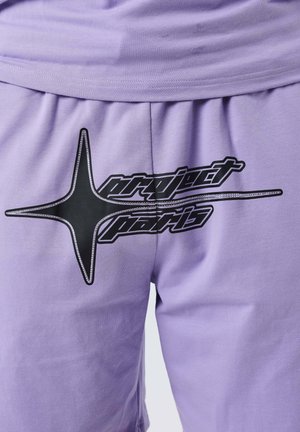 Shorts viola chiaro con un logo a forma di stella nera e la scritta "project paris" stampata sul davanti.