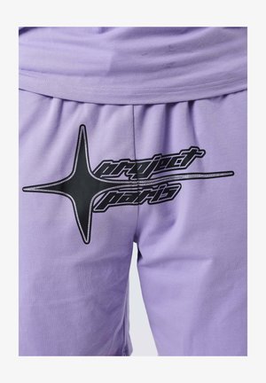 Pantalones cortos de color púrpura claro con un logo en forma de estrella negra y el texto "project paris" impreso en la parte delantera.