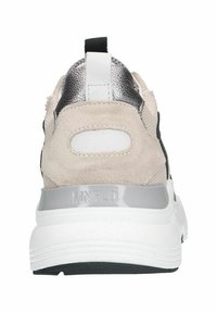 Rear view of a sneaker featuring a combination of beige suede and black fabric, metallic accents, white heel tab, and thick white sole.