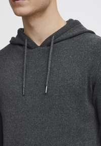 Dark gray hoodie with a textured, woven finish. It features a ribbed neckline and adjustable drawstrings with metallic tips.