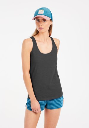 Black tank top with textured straps, paired with blue-and-teal striped shorts and a blue cap with a pink brim and logo patch.