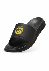 Sorte slip-on sandaler med en bred rem, der har et gult cirkulært logo og to stjerner. Tekstureret fodseng og glat gummiydersål.