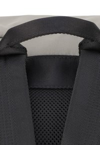 Czarny wyściełany uchwyt na teksturowanym czarnym tle z siateczki, otoczony eleganckim szarym materiałem, podkreślającym trwałość i chwyt.