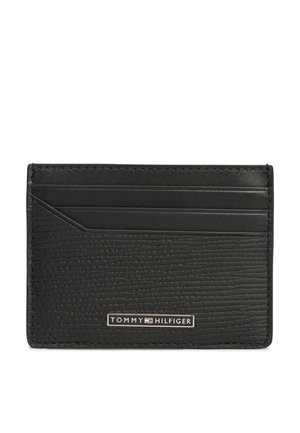 Must nahast tekstuuriga kaarditasku, millel on neli kaardipesa ja ees väike metallist Tommy Hilfiger logo plaat.