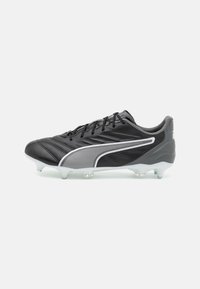 Scarpa da calcio nera con tomaia in pelle liscia, accenti bianchi e dettagli testurizzati. Presenta un profilo basso e tacchetti trasparenti per la trazione.