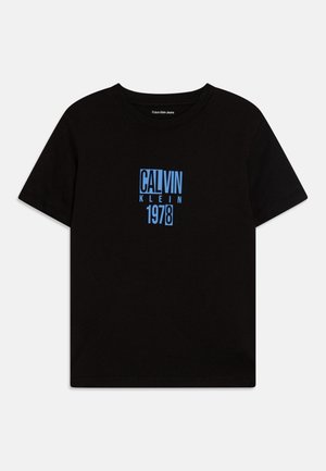 Camiseta de algodón negra con un estampado gráfico azul de "CALVIN KLEIN 1978" en el frente. Corte estándar con cuello redondo y mangas cortas.