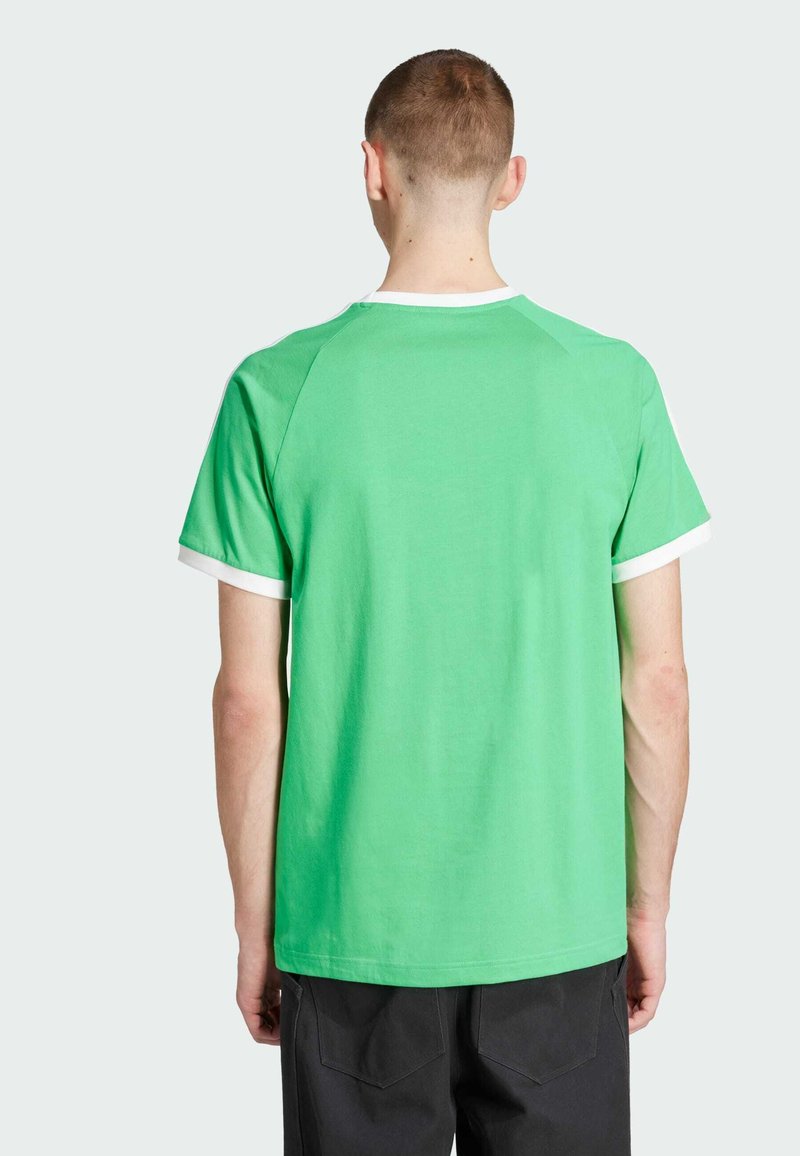 Camiseta de algodón verde con cuello y acentos de manga blancos. Mangas cortas, ajuste relajado, textura suave y diseño liso en la parte de atrás.