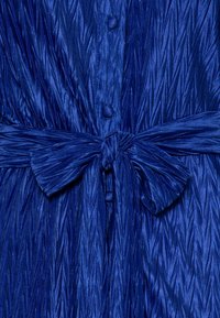 Blaues Plisseekleid aus strukturiertem Stoff, mit einem gebundenen Taillengürtel und Knopfverschlüssen, das ein glänzendes, glattes Finish zeigt.