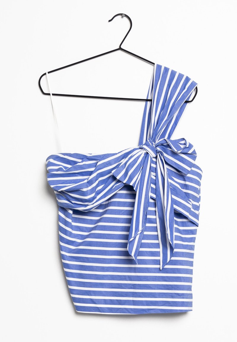 Robe asymétrique à rayures bleues et blanches avec un grand nœud sur la bretelle, suspendue à un cintre noir sur fond blanc.