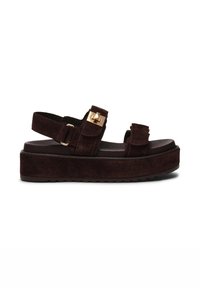 Bruine suède platform sandalen met twee verstelbare banden, gouden hardware-accenten en een gestructureerde zool. Chunky ontwerp met een platte voetbed.
