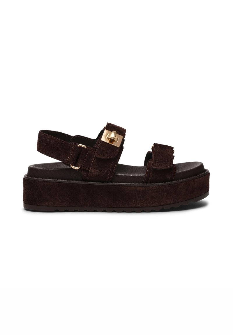Bruine suède platform sandalen met twee verstelbare banden, gouden hardware-accenten en een gestructureerde zool. Chunky ontwerp met een platte voetbed.