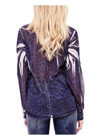 Koszula z długim rękawem, przezroczysta, w ciemnoniebieski wzór zwierzęcy z białymi kwiatowymi akcentami na ramionach oraz okrągłym wykończeniem dołu.