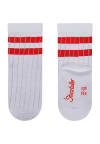 White cotton socks with red horizontal stripes. Features ribbed texture and printed logo in red on one side. Ankle length design.