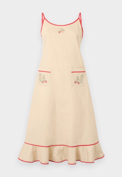 Μπεζ ποδιά φόρεμα με κόκκινες τιράντες και περιθώριο. Διαθέτει δύο μπροστινές τσέπες με κεντήματα φράουλας και φρουτόνι στο κάτω μέρος.