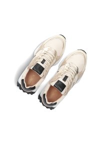 Beige sneakers with mesh upper, black leather accents, and white sole; rounded shape with textured detailing and contrasting laces.