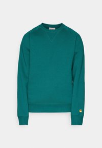 Sudadera verde de cuello redondo hecha de una tela suave, con puños y dobladillo acanalados. Presenta un pequeño parche con el logo en la manga izquierda.