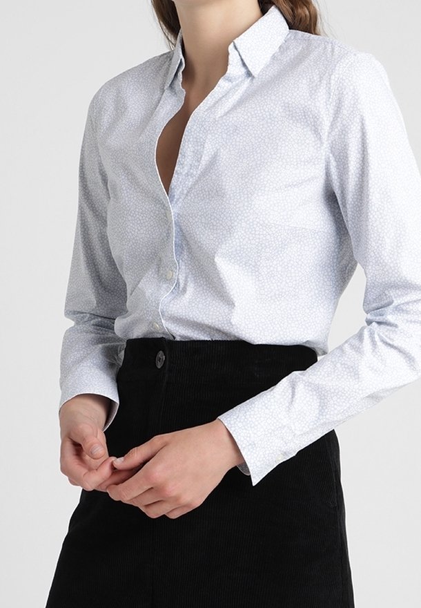 Camicia button-up azzurro chiaro con piccoli pois bianchi, colletto a punta e maniche lunghe, abbinata a una gonna in corduroy nera.