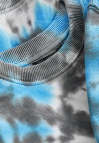 Bawełniany sweatshirt z niebiesko-szarym wzorem tie-dye, z prążkowanym okrągłym dekoltem i miękkim, teksturowanym materiałem.