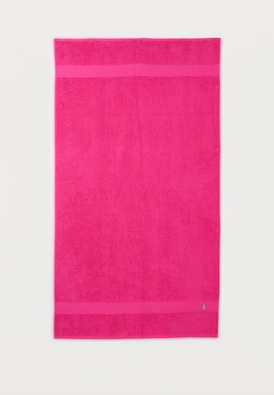 Φωτεινή ροζ ορθογώνια πετσέτα με δύο οριζόντιες ταινίες κοντά στις άκρες και μικρό αντίθετο μπλε κεντημένο λογότυπο στην κάτω δεξιά γωνία.