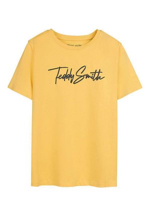 T-shirt jaune à manches courtes avec l'inscription "Teddy Smith" en écriture cursive noire sur la poitrine, sur fond blanc.