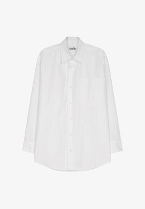 White long-sleeve button-up shirt with subtle vertical stripes, single front pocket, and rounded hem. Made from light, smooth fabric.