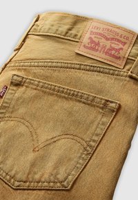 Levi's denim jeans in lichtbruin met een kenmerkende vorm van het achterzakje, oranje stiksels en een merkleren label met reliëfgraphics.
