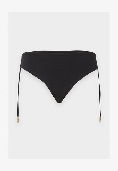 Μαύρο κάτω μέρος μπικίνι με πλαϊνά κορδόνια και χρυσές μεταλλικές λεπτομέρειες, απλωμένο σε φωτεινό φόντο.
