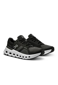 Schwarze Sportschuhe mit einem atmungsaktiven Mesh-Obermaterial, weißer Zwischensohle und auffälligen Dämpfungselementen. Verfügt über schwarze Schnürsenkel und Logoakzente.