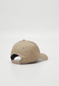 Casquette de baseball kaki à forme structurée, avec une fermeture métallique réglable à l'arrière et une texture en coton lisse. Pas de motifs ni de logos visibles.