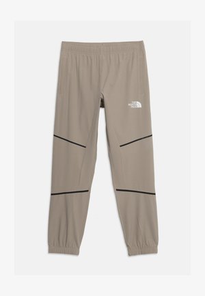 Pantalon de sport marron clair fuselé avec taille et poignets élastiques, rayures diagonales noires, poches latérales et logo The North Face sur la cuisse droite.