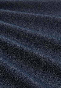 Donkerblauwe stof met een gestructureerd oppervlak, met horizontale plooien en een subtiel patroon, gemaakt van zacht materiaal.