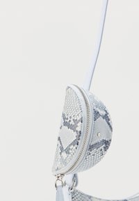 Μικρό τσαντάκι χιαστί σε σχήμα ημισελήνου με μπλε και λευκή υφή δέρματος φιδιού και ασημένιο φερμουάρ, κρεμασμένο από λεπτό λουρί.