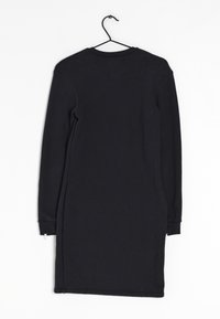 Svart, långärmad klänning i bomull med rak skärning. Har rundad halsringning och dragkedjedetaljer vid sidorna.