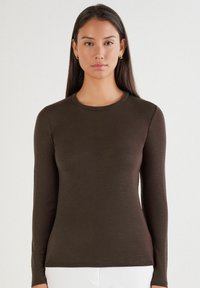 Braunes Langarmshirt mit Rundhalsausschnitt, aus dehnbarem Stoff, mit tailliertem Schnitt und glatter Textur. Minimale Nähedetails.
