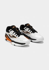 Zapatillas deportivas blancas con detalles en negro y naranja, que presentan una parte superior texturizada, un sistema de cordones y una suela acolchada. Con marca en el lateral.