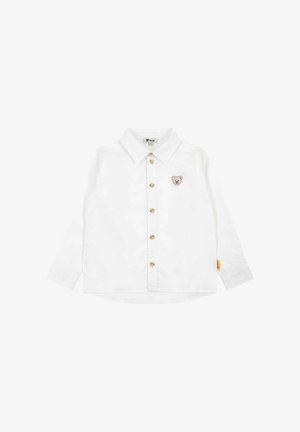 Chemise blanche à manches longues pour tout-petit, avec col et petite écusson ourson sur la poitrine, équipée de boutons marron.